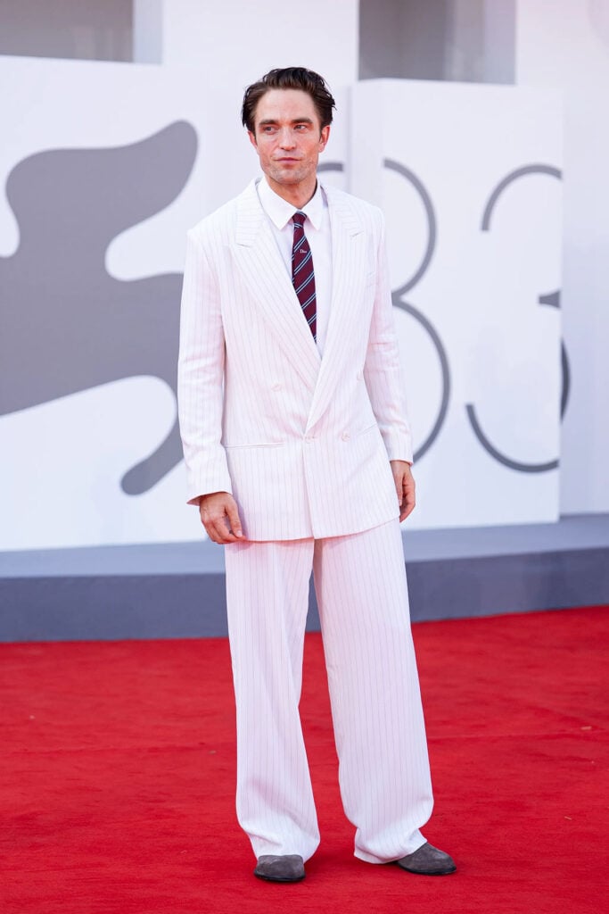 Robert Pattinson wears a white pinstriped Dior suit to the Primetime premiere at the 2026 Venice Film Festival.