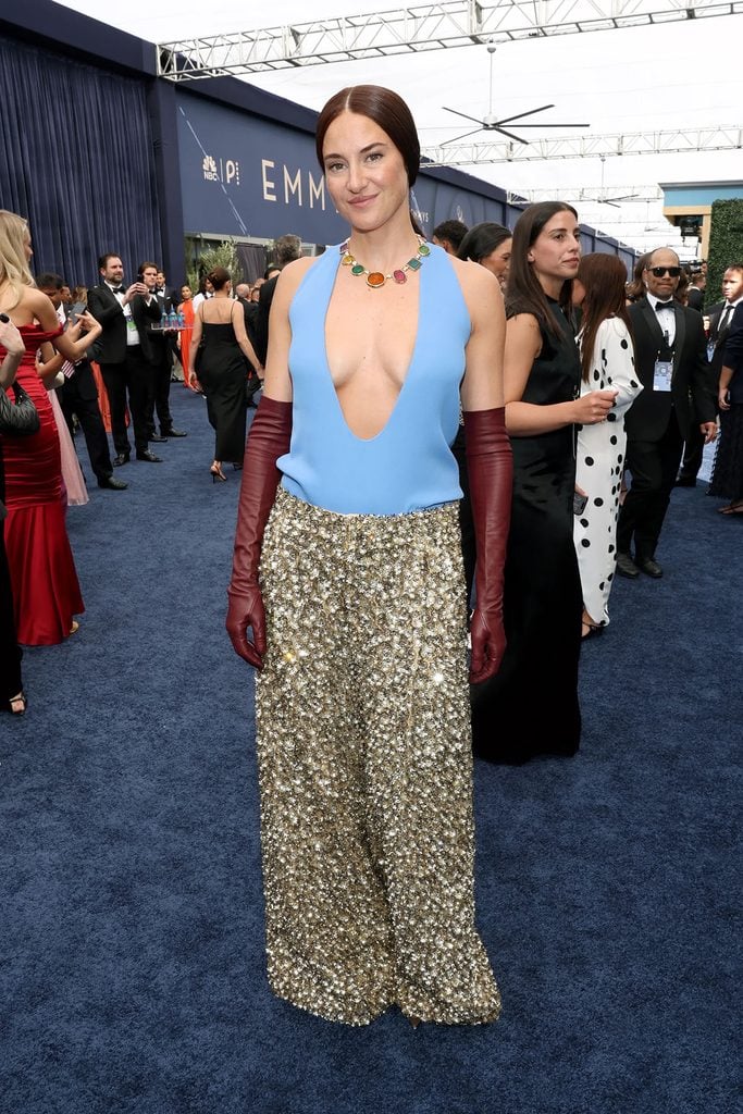 Shailene Woodley wearing burgundy leather gloves and a gemstone necklace with her Balenciaga look on the 2026 Emmys red carpet.