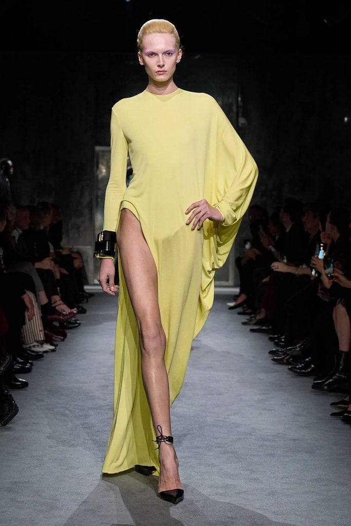 Tom Ford by Haider Ackermann Fall 2025 yellow high-slit dress on the runway.