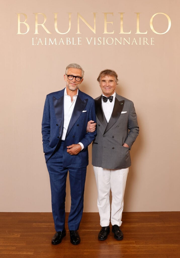 Vincent Cassel wears a blue Brunello Cucinelli double-breasted suit alongside Brunello Cucinelli at the Paris boutique celebration.