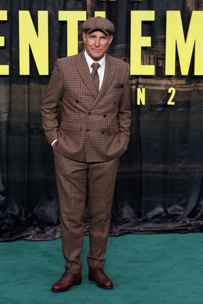 Vinnie Jones wears a brown checked double-breasted suit and flat cap at The Gentlemen Season 2 London premiere.