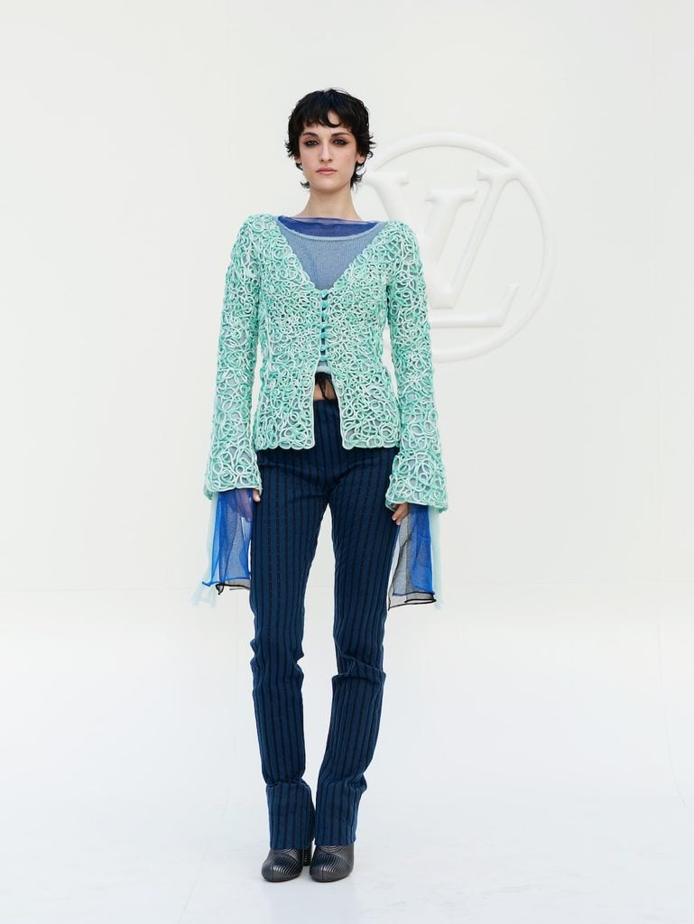 Olivia Nuss wearing a textured mint Louis Vuitton jacket with pinstriped trousers at the Spring-Summer 2027 show in Paris.