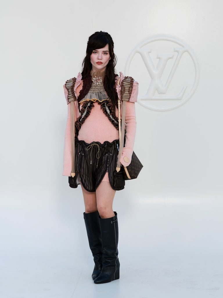 Sophie Thatcher wearing a deconstructed pink Louis Vuitton look with black boots at the Spring-Summer 2027 show in Paris.