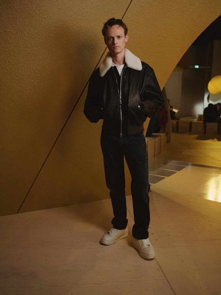 Anson Boon wearing a Givenchy leather bomber jacket with jeans at the Givenchy Spring 2027 show in Paris.