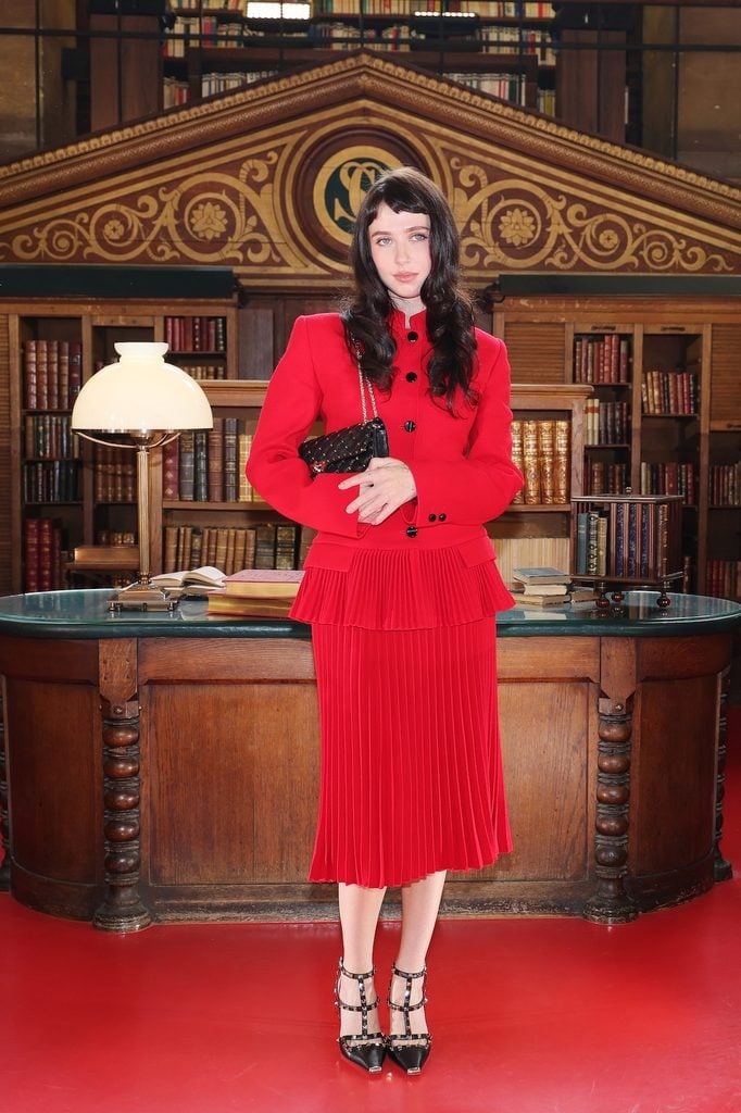 Clairo wearing red Valentino with black Rockstud pumps at the Valentino Spring 2027 show in Paris.