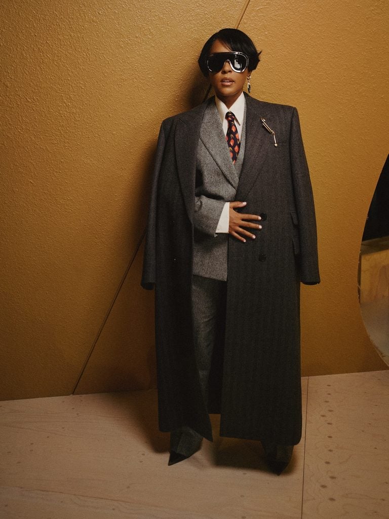 Janelle Monáe wearing grey Givenchy tailoring with a patterned tie at the Givenchy Spring 2027 show in Paris.