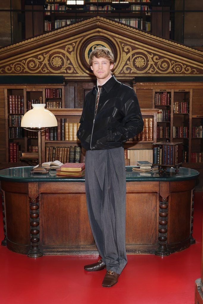 Joe Alwyn wearing a black Valentino jacket and grey trousers at the Valentino Spring 2027 show in Paris.