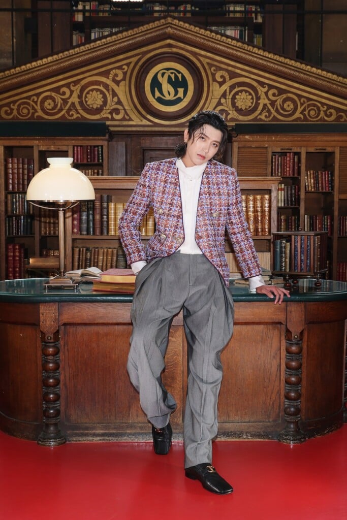 KUN wearing a Valentino tweed jacket and grey trousers at the Valentino Spring 2027 show in Paris.