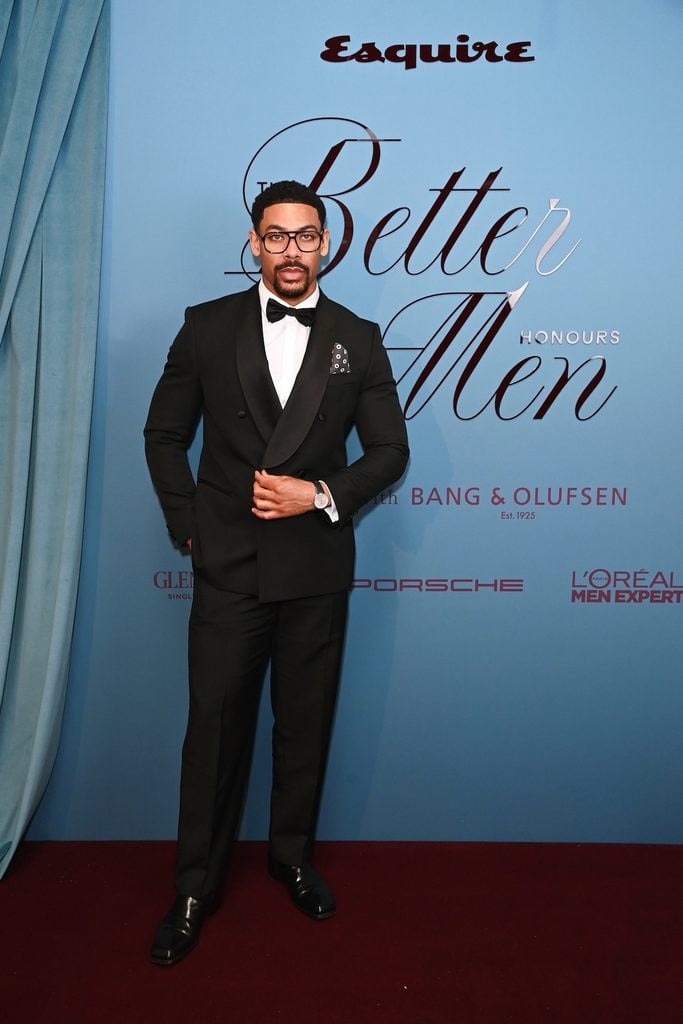 Aaron Pierre wearing a black BOSS double-breasted tuxedo with a polka-dot pocket square at Esquire UK's Better Men Honours in London.