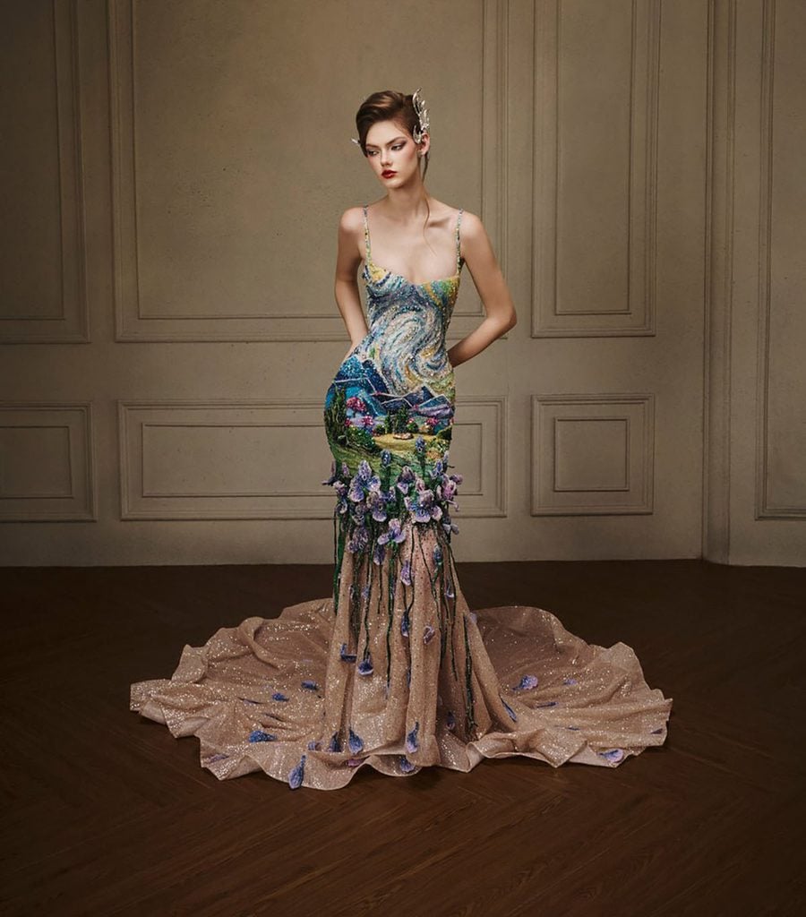 Almée Couture model wearing the embroidered landscape gown with purple floral appliqués and a sweeping train, later worn by Mckenna Grace at The Hunger Games: Sunrise on the Reaping London premiere.