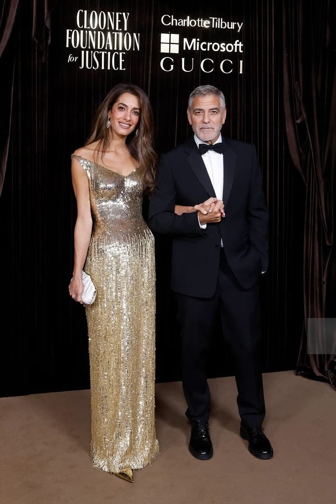 Amal Clooney in a gold Gucci gown alongside George Clooney in a black Gucci tuxedo at the 2026 Albies.