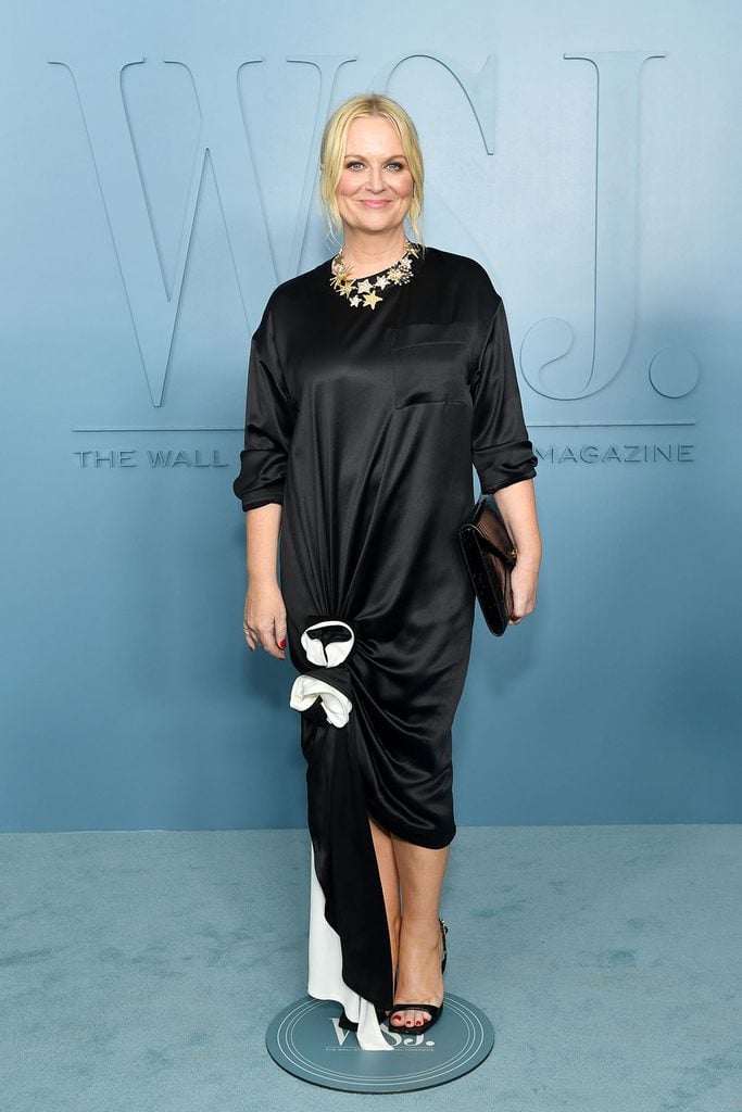 Amy Poehler wears a black Chanel Spring 2026 satin dress with white gathered detailing, a statement necklace and black sandals at the 2026 WSJ. Magazine Innovator Awards.