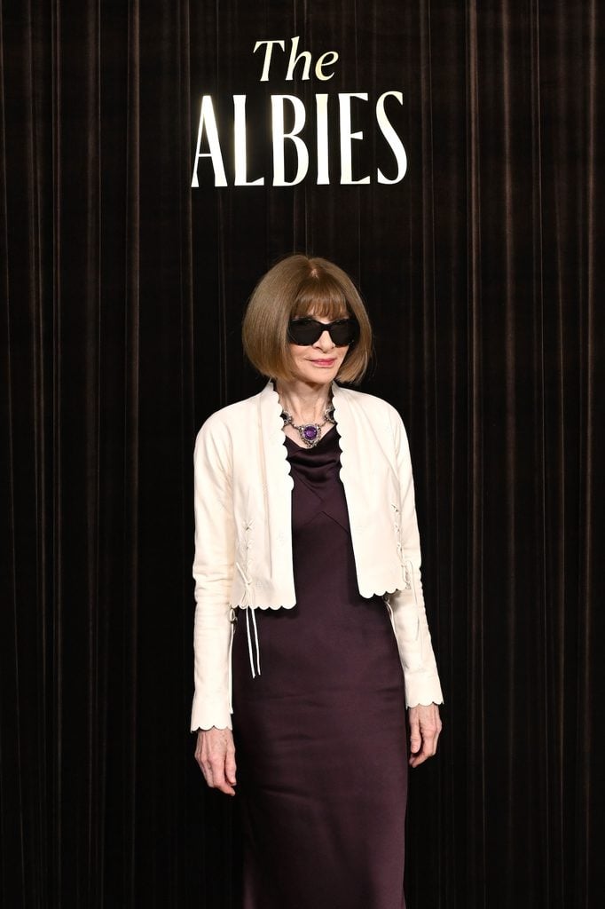Close up of Anna Wintour wearing a plum satin gown with a cropped ivory jacket and statement necklace at the 2026 Albies in London