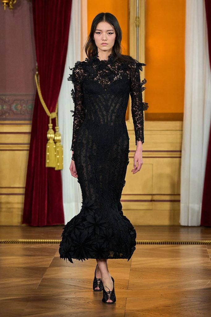 Model wearing the original black floral lace gown from the ArdAzAei Fall 2026 Couture runway collection