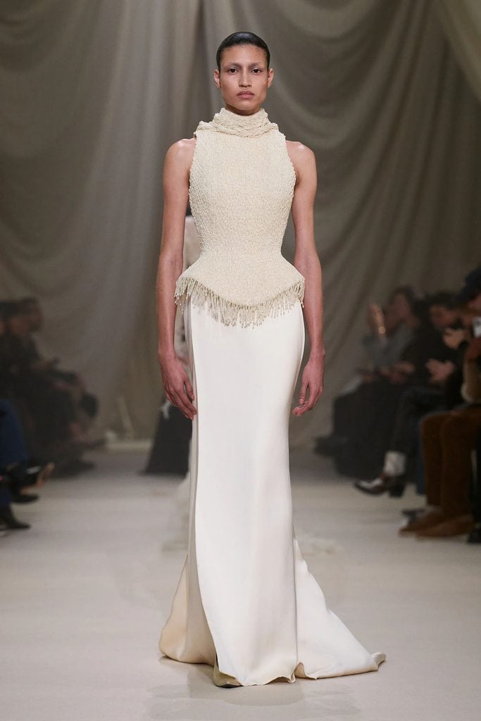 Ashi Studio Spring 2026 Haute Couture runway model wears the ivory pearl-embellished corset gown with beaded fringe and silk skirt later worn by Naomi Watts in Mexico City.