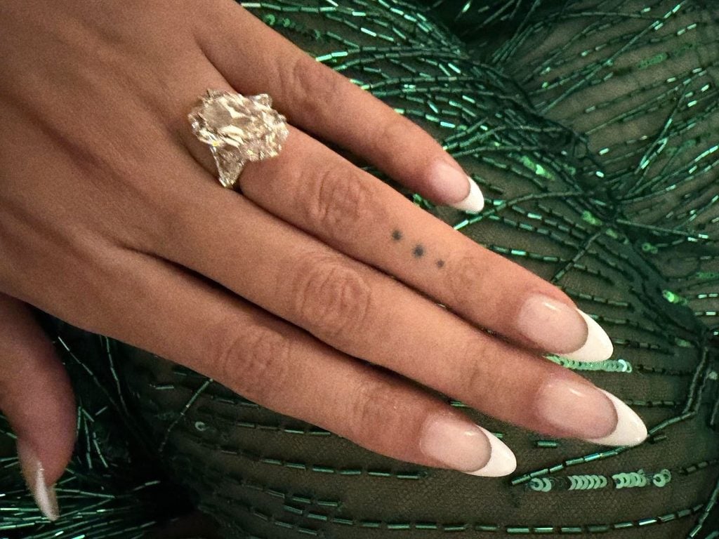 Close-up of Beyoncé's large diamond ring and French-tip manicure against the emerald-green sequinned fabric of her Roberto Cavalli skirt.