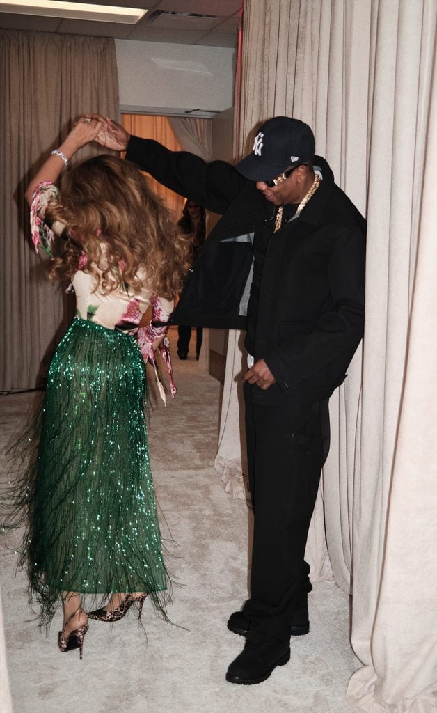 JAY-Z twirls Beyoncé backstage, revealing the back of her Roberto Cavalli floral top, green fringed skirt and leopard-print heels.