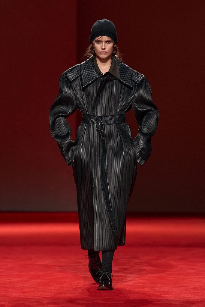 Bottega Veneta Fall 2026 runway model wearing the black leather plissé coat with an intrecciato collar and matching belt