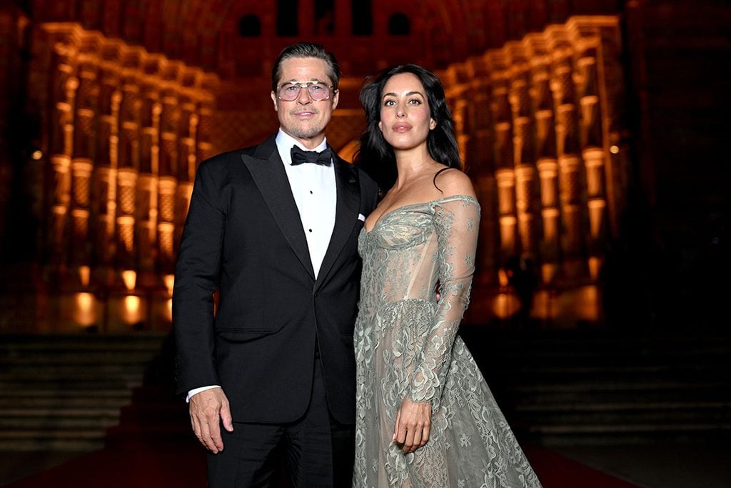 Brad Pitt wearing aviator sunglasses alongside Ines de Ramon in an off-the-shoulder lace gown at the Clooney Foundation for Justice's 2026 Albies.