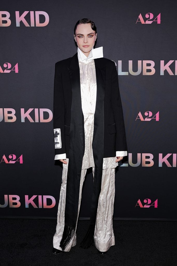 Cara Delevingne wears an oversized black Erdem Spring 2027 jacket with an ivory ensemble at the Club Kid New York premiere.