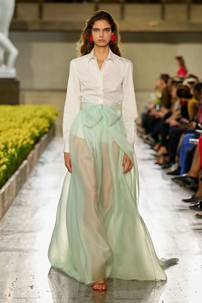 Model wearing a white shirt and sheer cucumber-green bow-detail skirt on the Carolina Herrera Spring 2027 runway