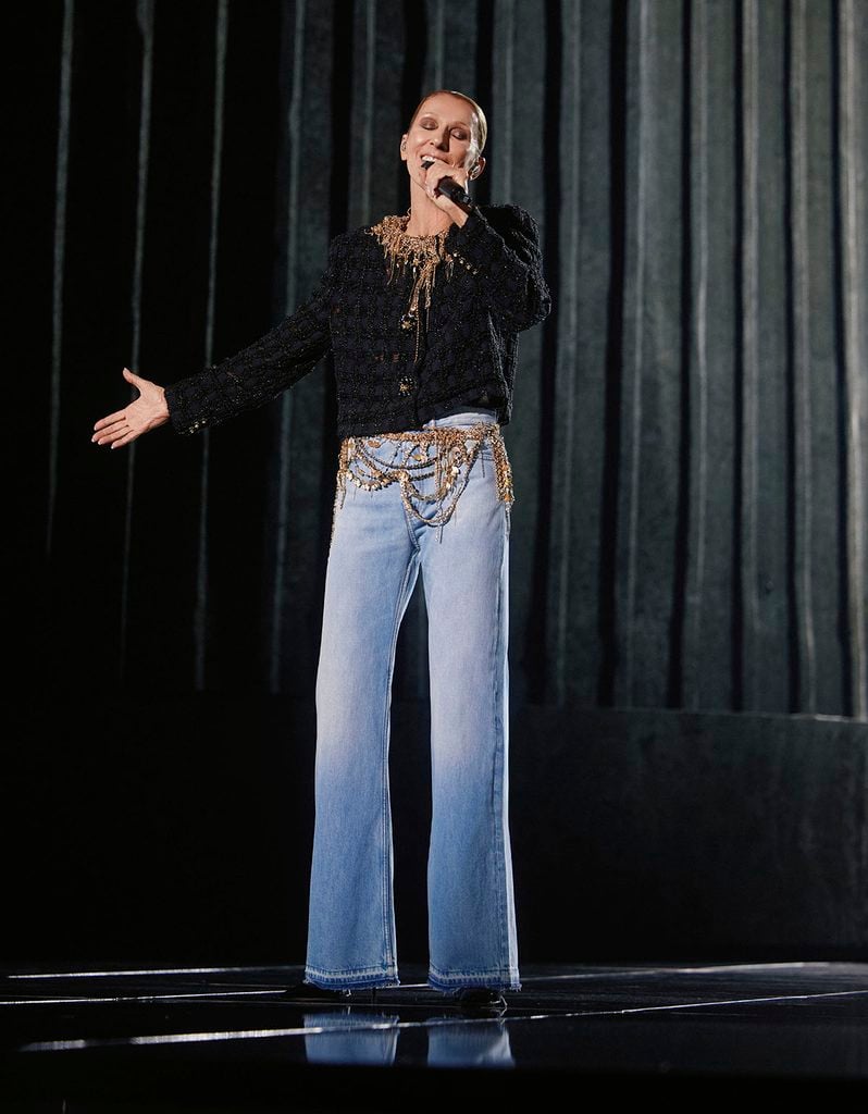 Céline Dion performs at the final show of her Paris residency wearing a black Chanel Fall 2026 Haute Couture jacket with gold chain embellishments and wide-leg jeans.