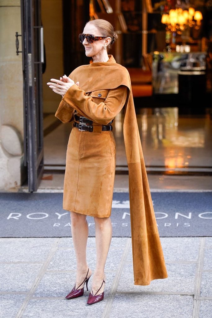 Céline Dion leaving her Paris hotel in a caramel suede Ferragamo Spring 2027 ensemble with a long draped stole and burgundy slingbacks
