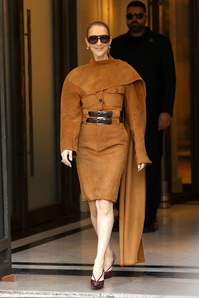 Céline Dion wearing Ferragamo Spring 2027 caramel suede with a floor-length stole and burgundy slingback heels outside her Paris hotel