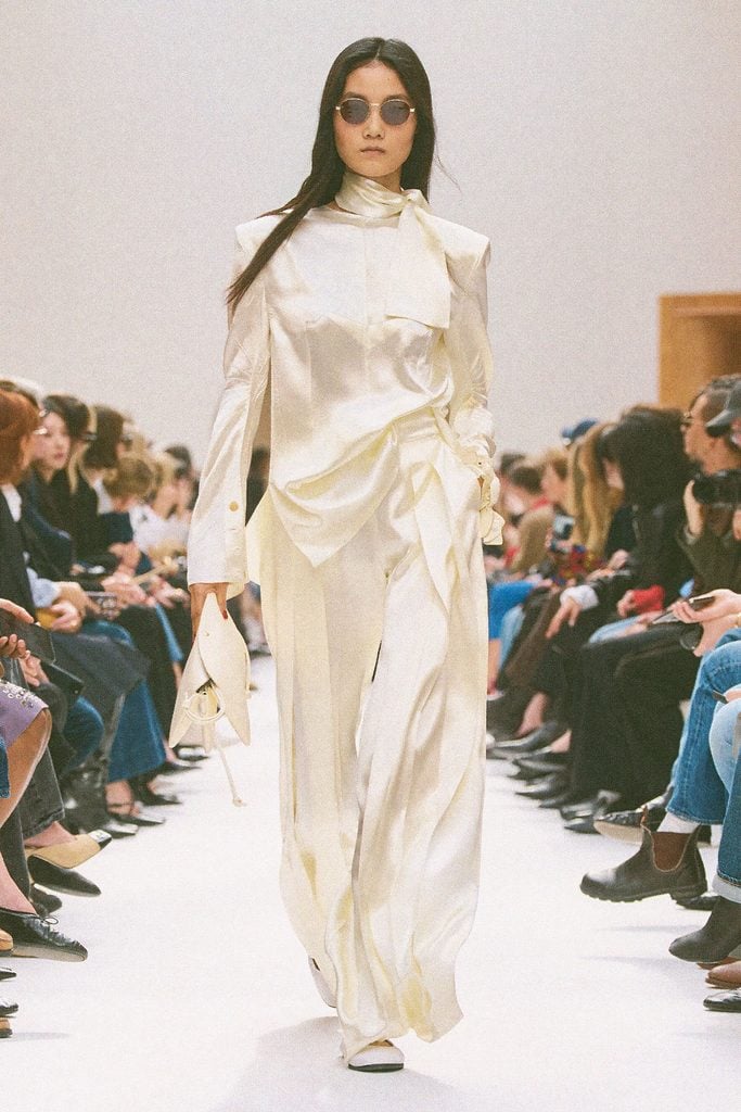 Celine Fall 2026 runway model wearing an ivory satin ensemble with wide-leg trousers, a look later worn by Tracee Ellis Ross at the WWD Honors.