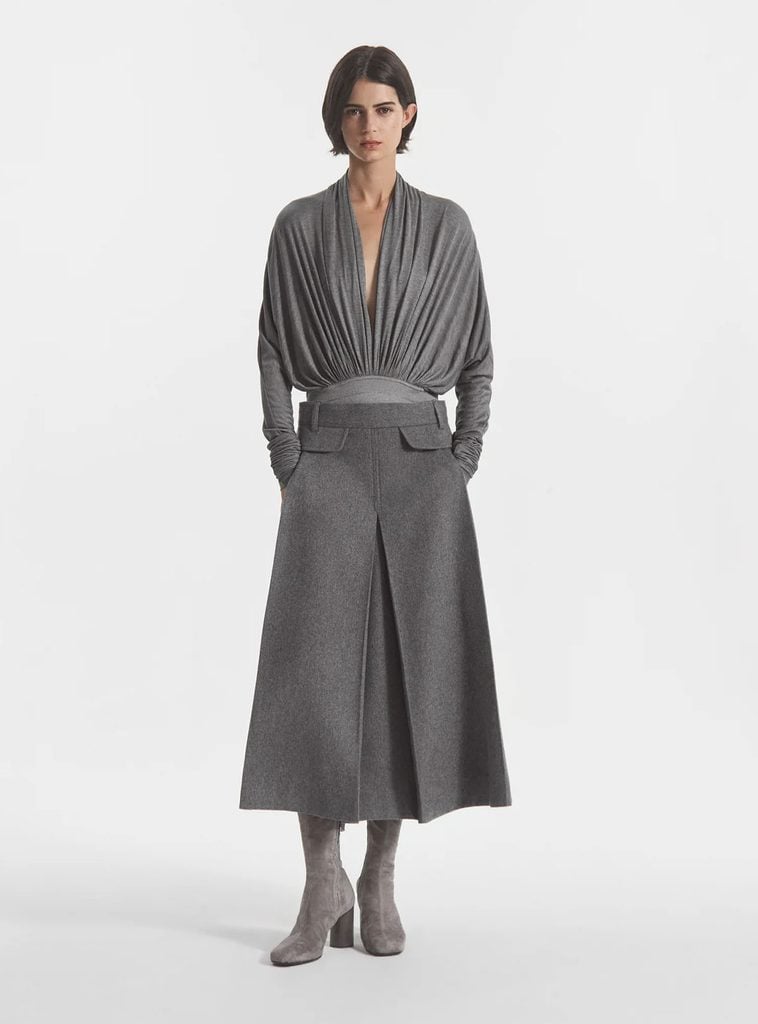 CO lookbook model wearing a grey gathered jersey bodysuit with a matching midi skirt and suede boots, showing the original styling of Amy Adams' photocall look.