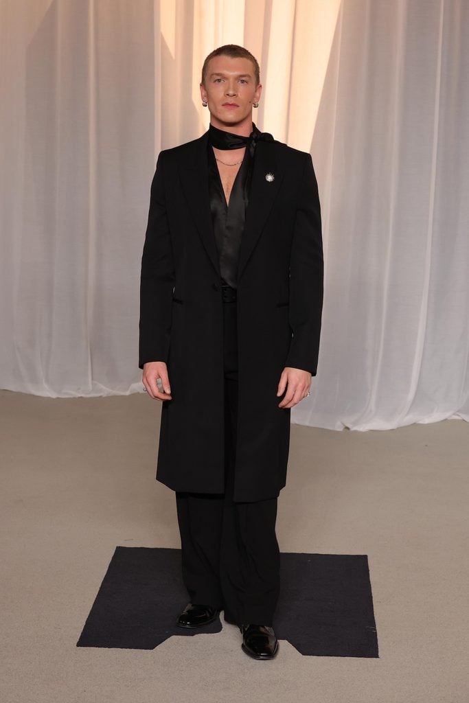 Connor Storrie wearing a black Saint Laurent coat and satin shirt with Tiffany & Co. jewellery at the 2026 Academy Museum Gala