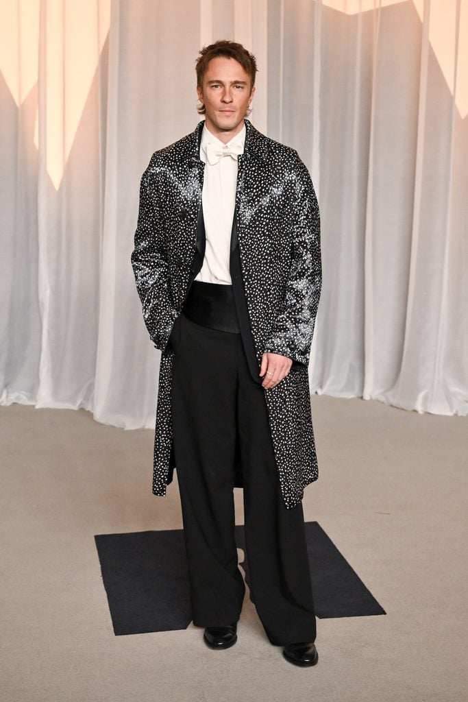 Drew Starkey in a black-and-white Dior silk coat over a tuxedo at the 2026 Academy Museum Gala