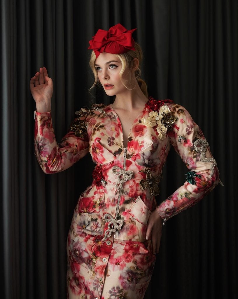 Elle Fanning shows the floral appliqués, jewelled bows and zip-front detailing on her Andreas Kronthaler for Vivienne Westwood jacket during The Hunger Games: Sunrise on the Reaping London press tour.