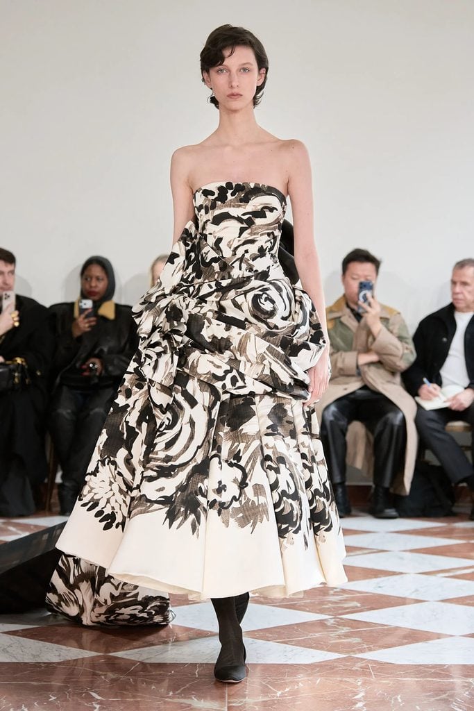Model wearing the Emilia Wickstead Fall 2026 painterly floral strapless gown with a trailing train on the runway.