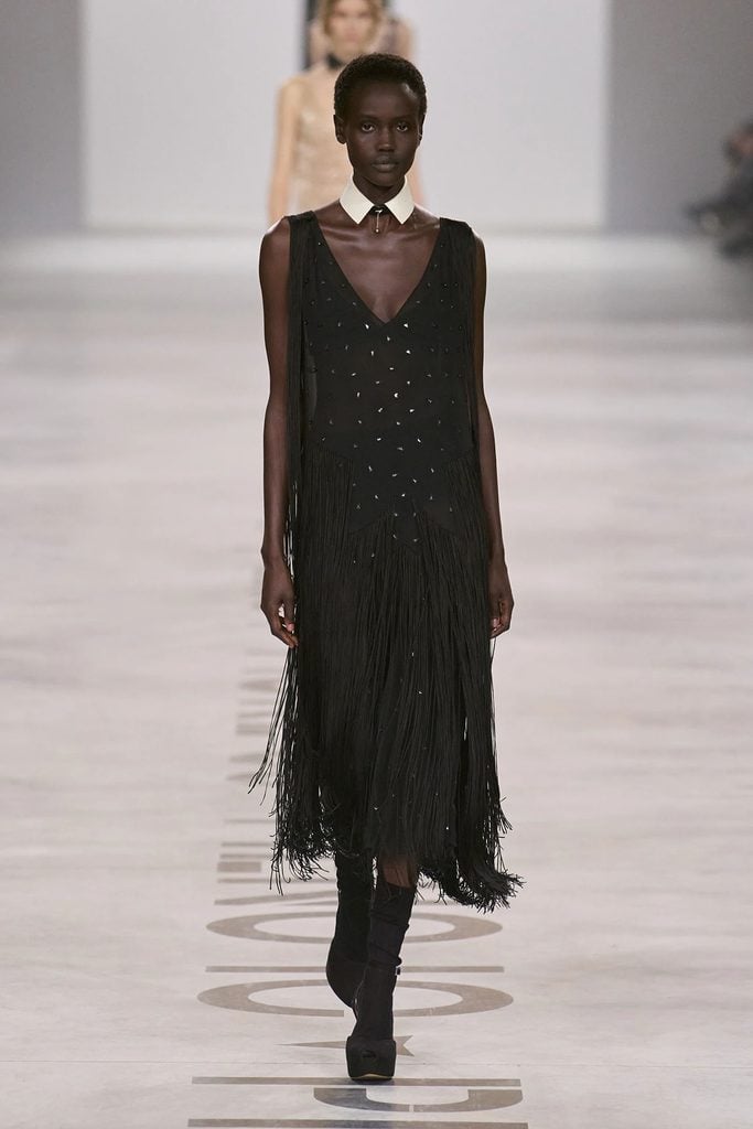 Model wearing a layered black dress with fringe and a leather collar from the Fendi Fall 2026 runway collection.