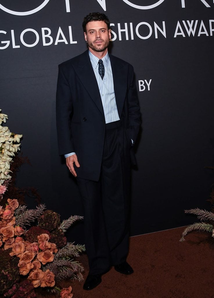 François Arnaud attends the 2026 WWD Honors wearing Saint Laurent by Anthony Vaccarello tailoring, styled with a striped shirt and tucked-in tie.