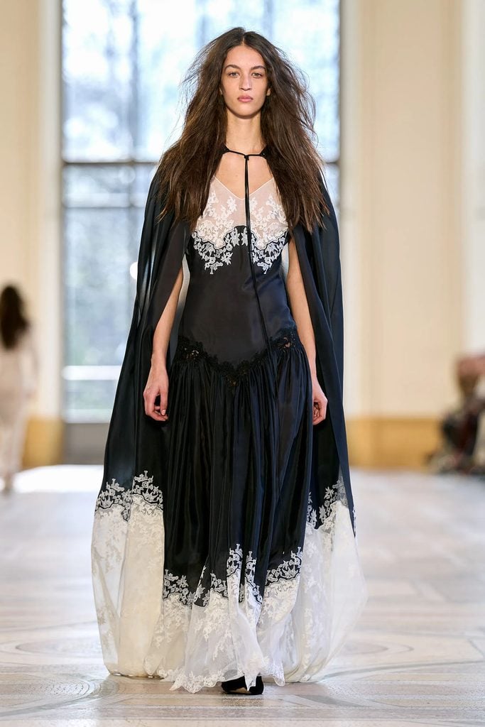 Gabriela Hearst Fall 2026 runway model wearing the black and ivory Neville dress and embroidered Dimsdale cape