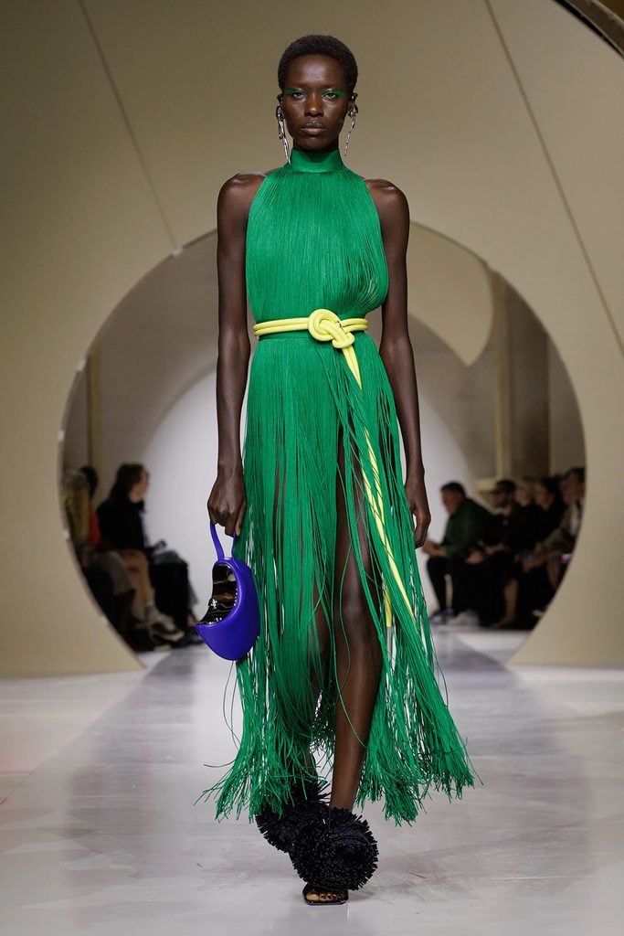 Givenchy by Sarah Burton Spring 2027 runway look 36, featuring the green fringed dress with a yellow knotted belt later worn by Charlize Theron to the Airbnb.org Gala.