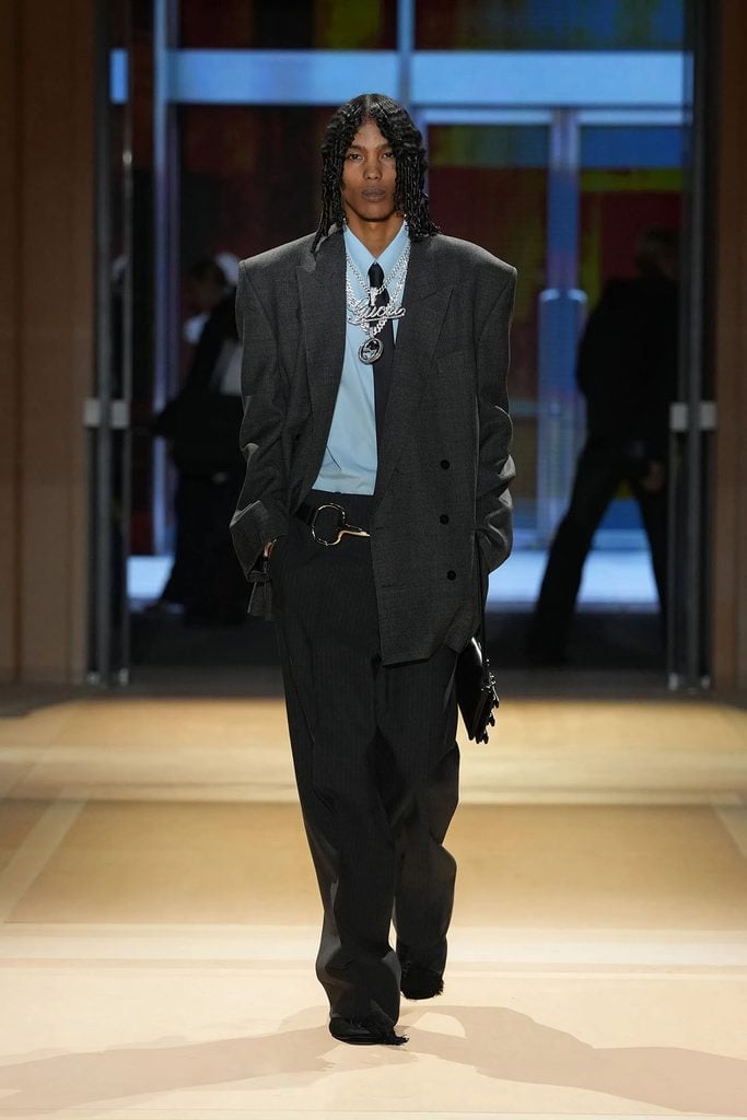 Gucci Spring 2027 menswear look from The Store show featuring the oversized grey suit, pale blue shirt and black tie later worn by Joseph Zada.