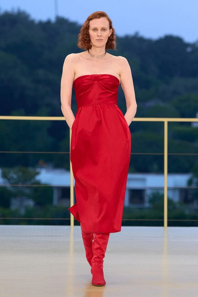 Hermès Resort 2027 runway model wearing the red strapless gathered dress with matching red boots, later worn by Scarlett Johansson at the London Film Festival