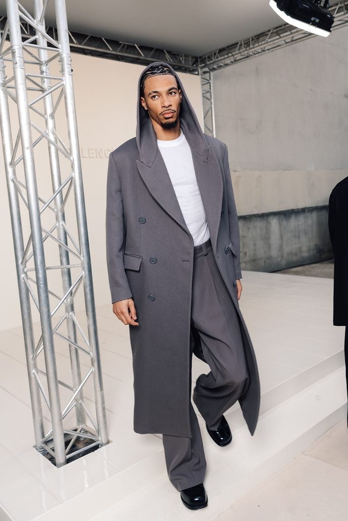 Hugo Ekitiké wearing grey Balenciaga tailoring with a Chopard watch at the Spring 2027 show in Paris.