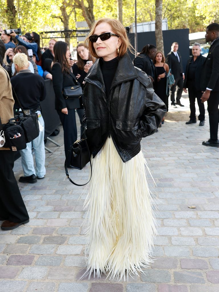 Isabelle Huppert wearing a black leather jacket with an ivory fringed Balenciaga skirt at the Spring 2027 show.