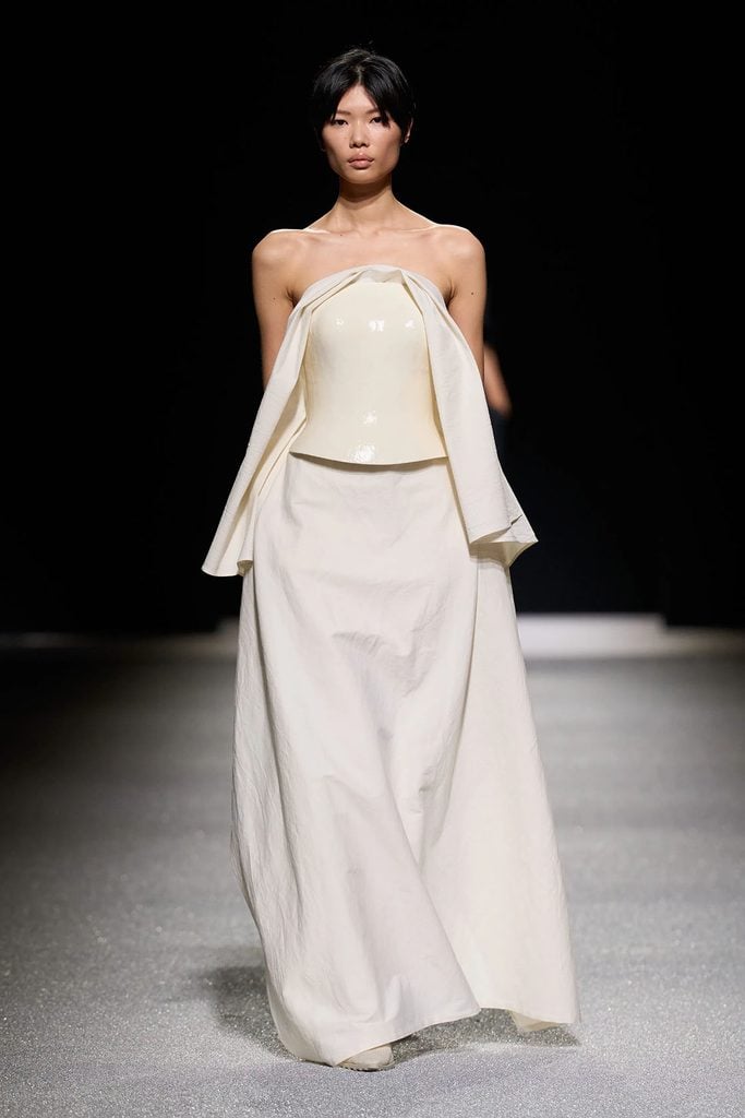 Model wearing the Issey Miyake Fall 2026 ivory runway design with a sculptural bodice and draped panels, later worn by CaitrĂona Balfe.