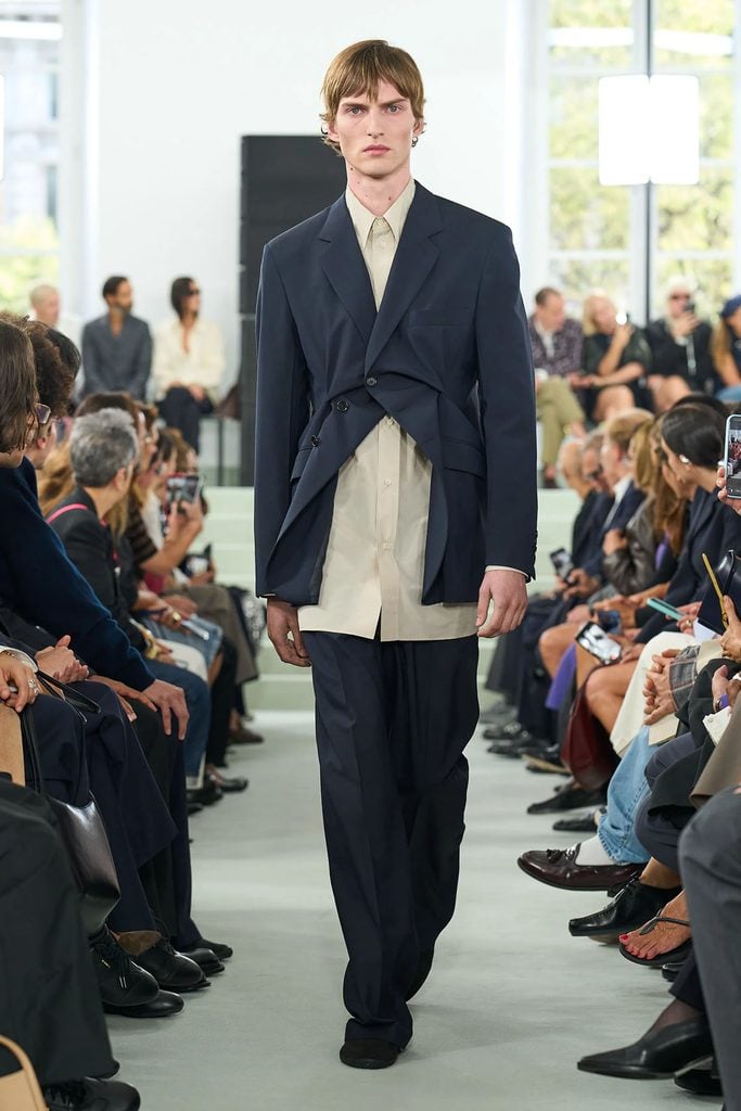 Model wearing the navy twisted jacket, long shirt and trousers from Jil Sander Spring 2027.