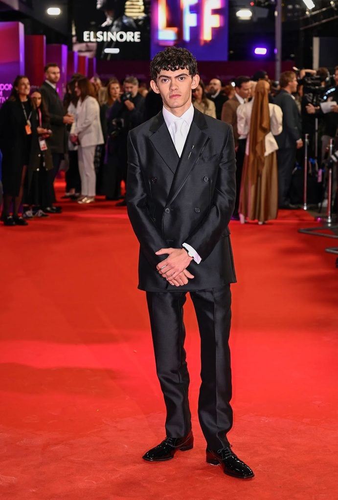 Joe Locke wearing a black Hermès Fall 2026 double-breasted suit with a white shirt and tonal tie at the 'Elsinore' BFI London Film Festival opening gala.