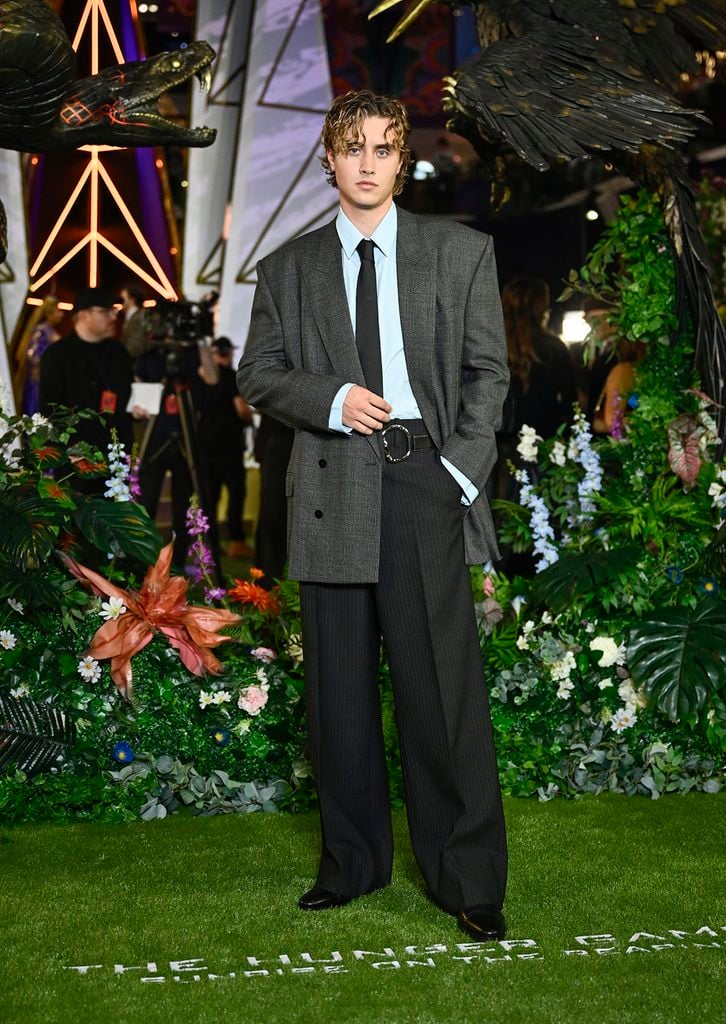 Joseph Zada wears a grey Gucci Spring 2027 suit with a pale blue shirt and black tie at The Hunger Games: Sunrise on the Reaping premiere.
