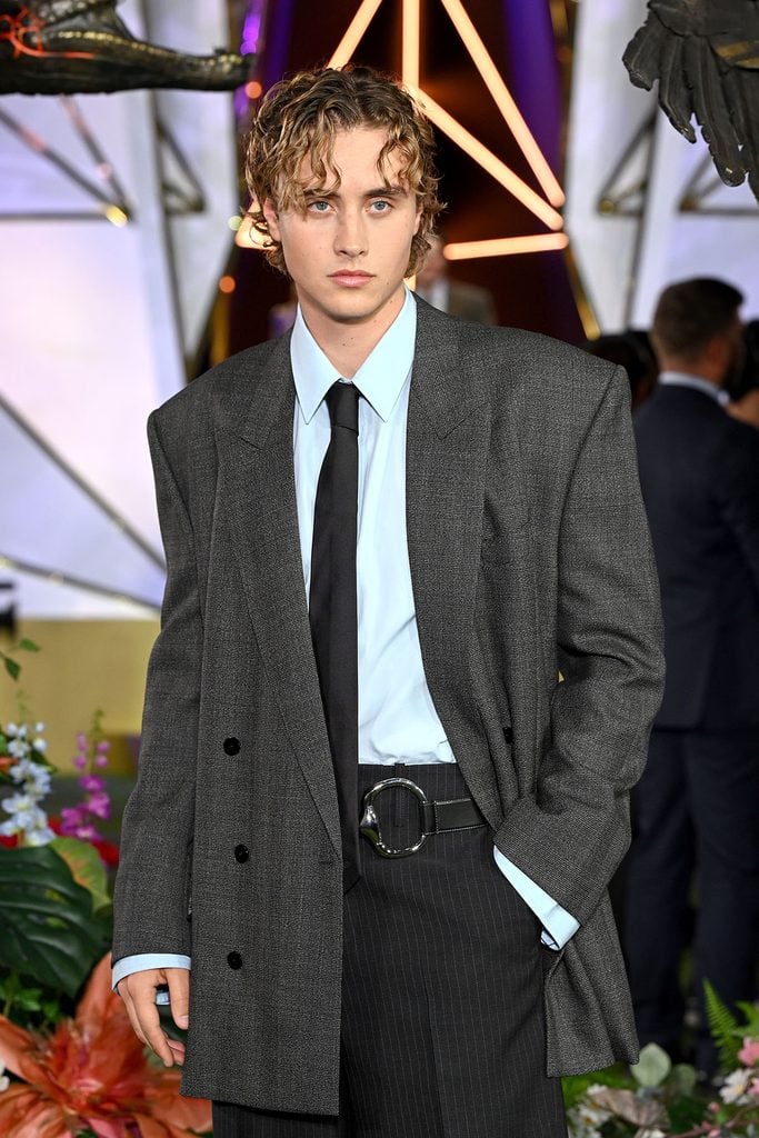 Joseph Zada wears an oversized grey Gucci blazer with a black tie and pinstriped trousers at The Hunger Games: Sunrise on the Reaping premiere, styled by Jason Bolden.
