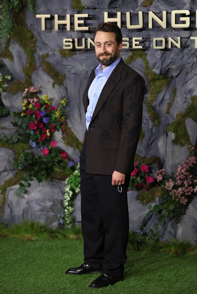 Kieran Culkin wears a dark brown McQueen jacket with lace argyle embroidery, powder-blue shirt and black trousers at the Hunger Games: Sunrise on the Reaping London premiere.