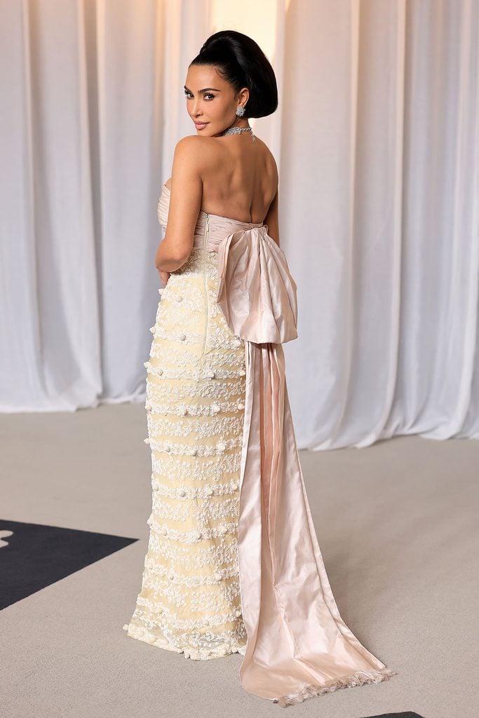 Kim Kardashian showing the pink satin bow and long train of her archival Balenciaga gown at the Academy Museum Gala