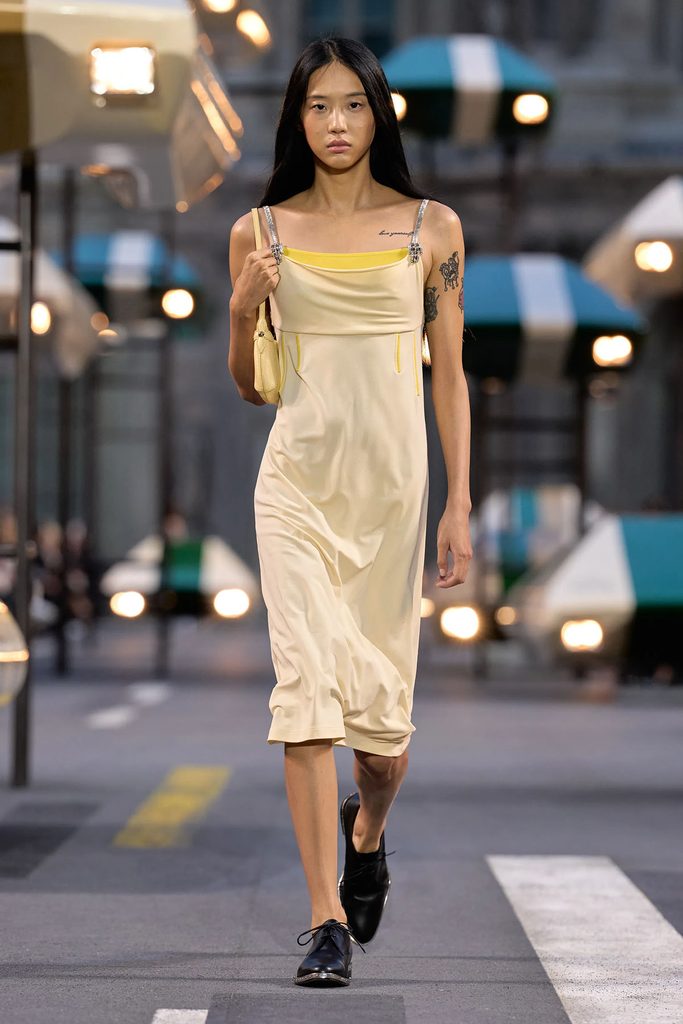Model wearing a cream slip dress with yellow accents from the Louis Vuitton Spring 2027 ready-to-wear collection in Paris.